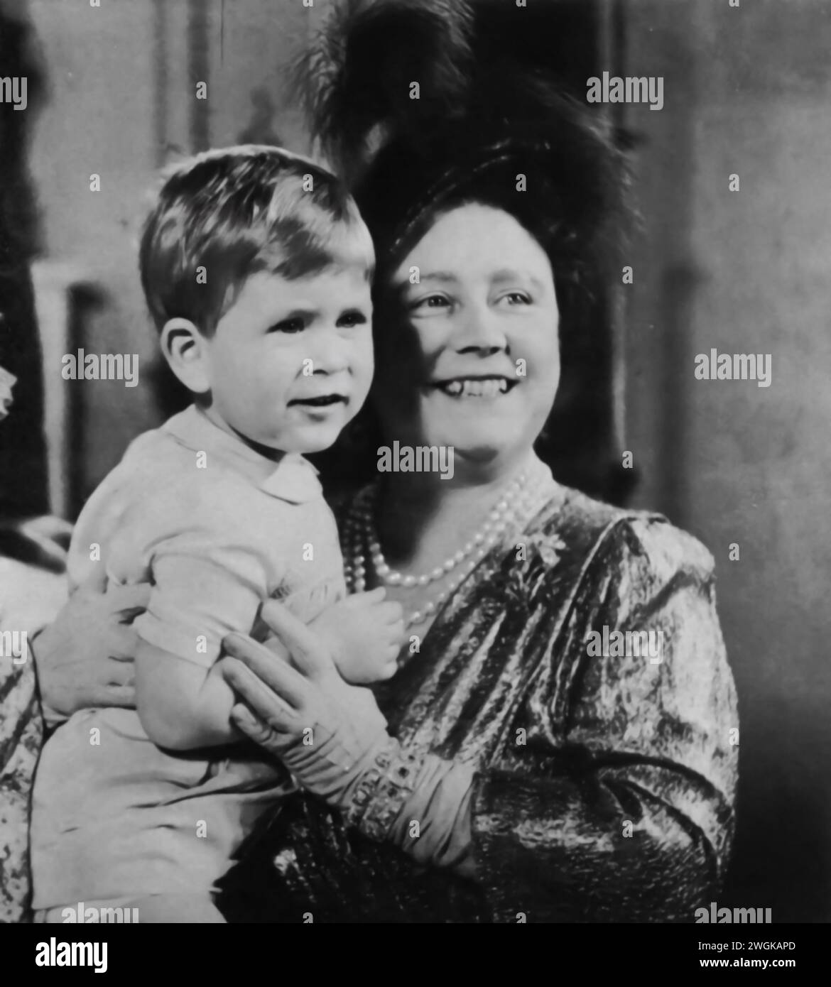 A young Prince Charles III is shown posing for the camera with Elizabeth I, known as the Queen Mother. This photograph captures a moment between the future King Charles III and his grandmother, offering a glimpse into the close relationship within the royal family. Stock Photo