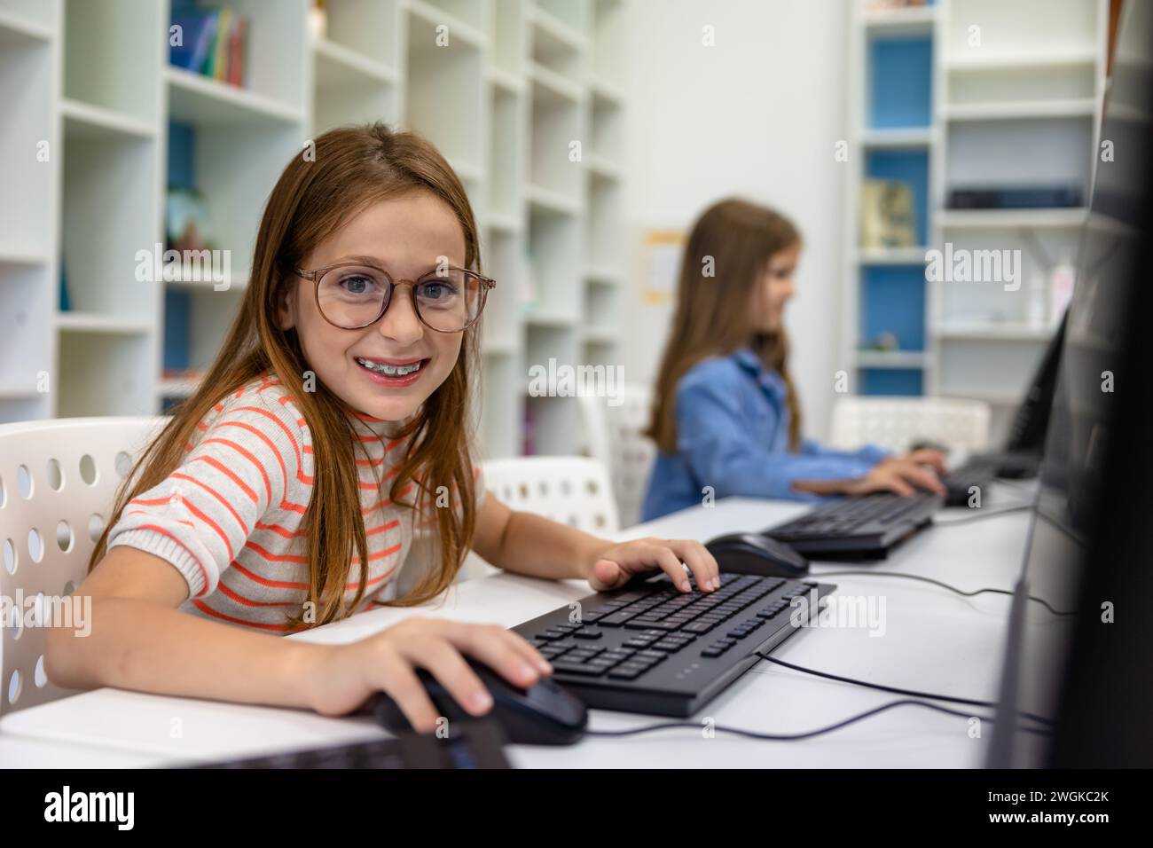 Little girl studying in school library Stock Photo - Alamy