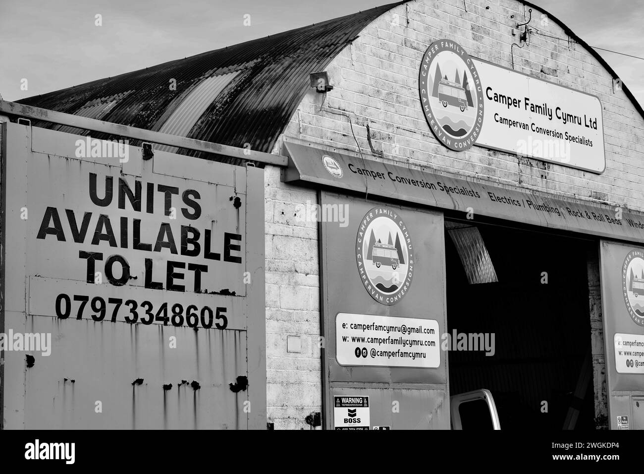 Barry, Vale of Glamorgan, Wales 02 Feb 2024: A vacant industrial unit to let, A large sign with black letters on a bright yellow door. Stock Photo