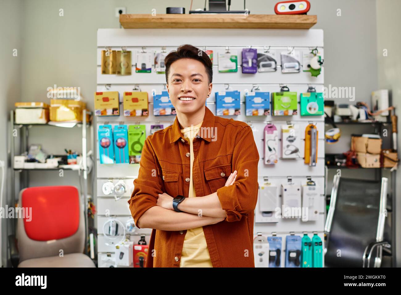 happy asian store manager smiling at camera near counter of private electronics shop, small business Stock Photo