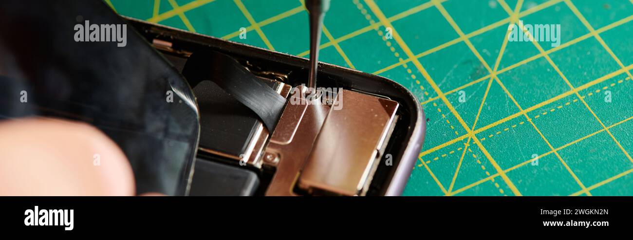 partial view of technician opening smartphone with screwdriver in repair shop, horizontal banner Stock Photo