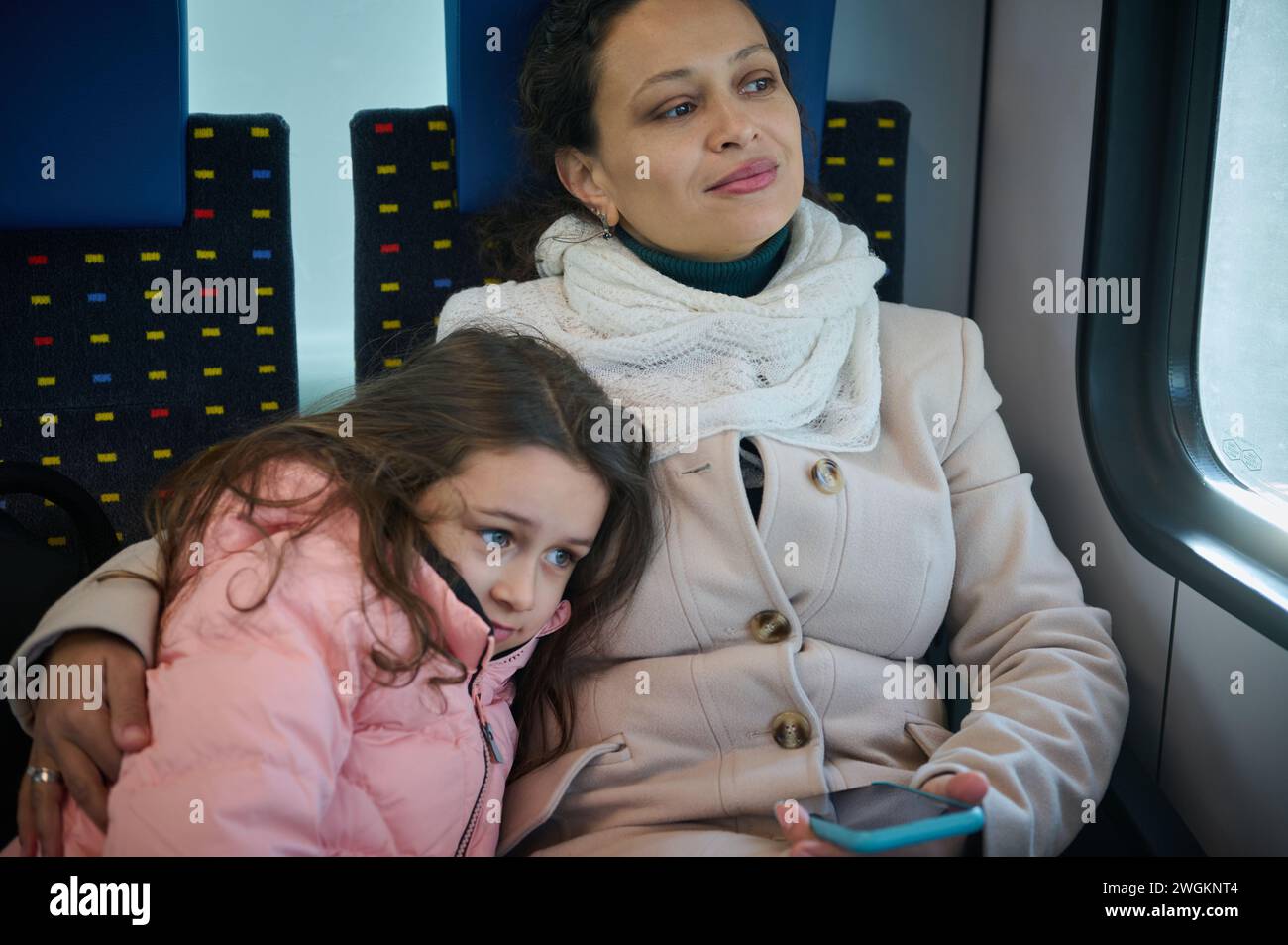 Young woman, happy mother hugging her little daughter, travelling