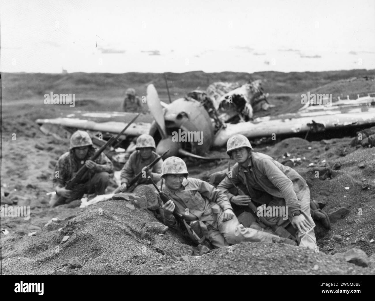 First Lieutenant Arthur Carley, from Ohio, finds shelter for his platoon near a wrecked Zero by Motoyama Airfield. Iwo Jima, Japan. 23 February, 1945. Company E, 2nd Battalion, 23rd Marine Regiment, 4th Marine Division. Stock Photo