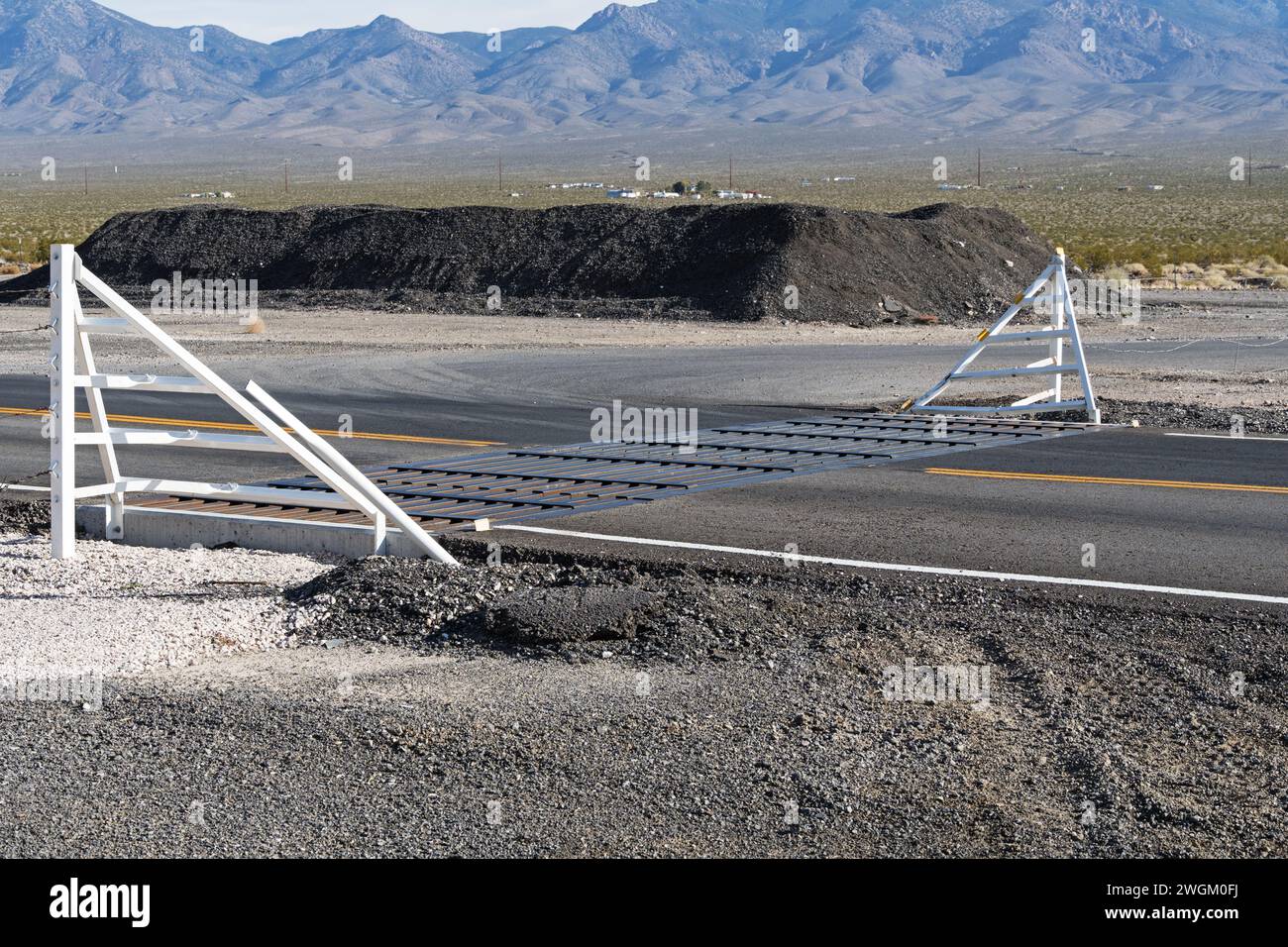 cattle guard and fence on paved road in the desert of Nevada Stock Photo