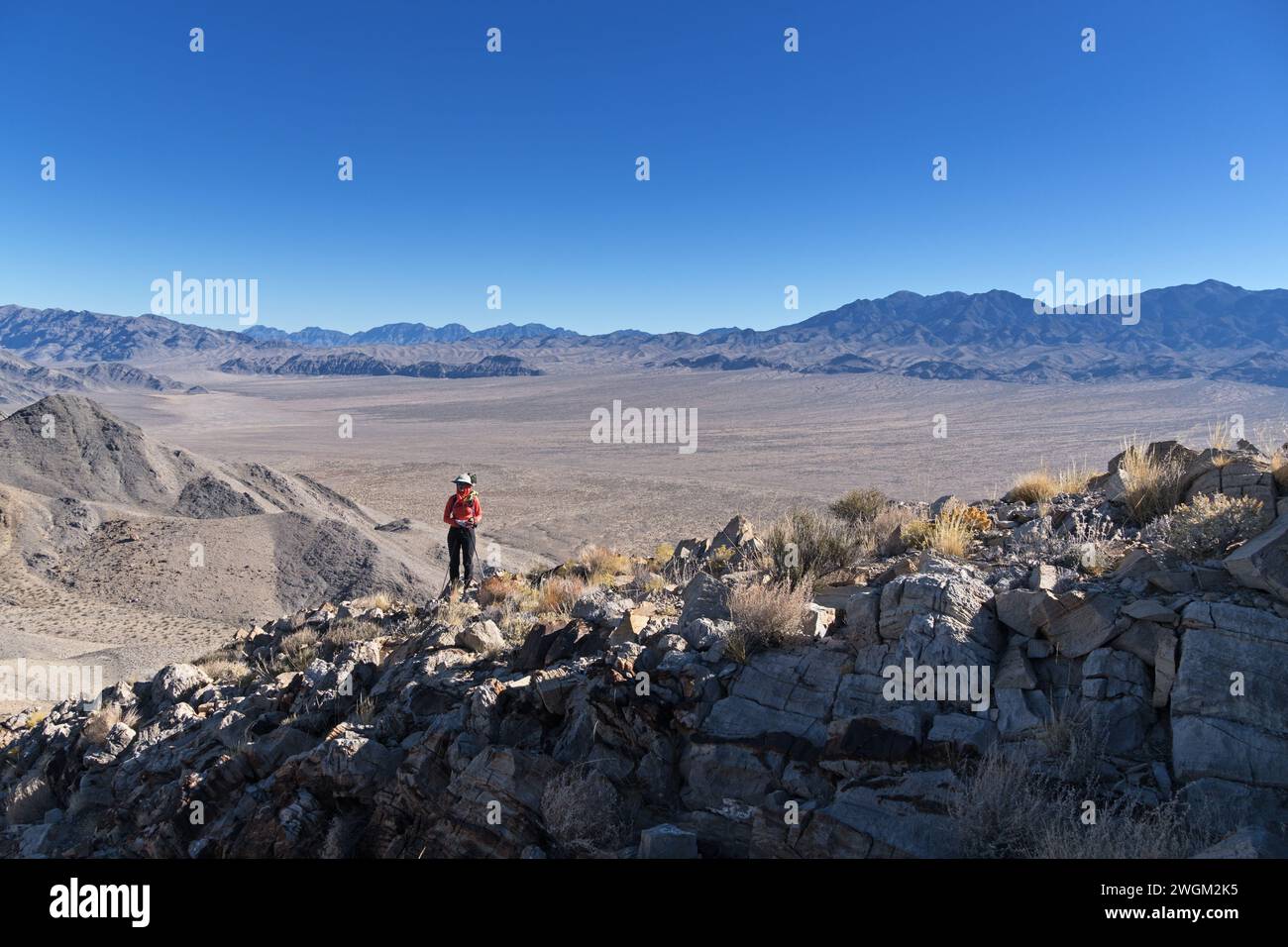 woman on a rocky limestone ridge on Target Benchmark Peak in the Desert National Wildlife Refuge in Nevada Stock Photo