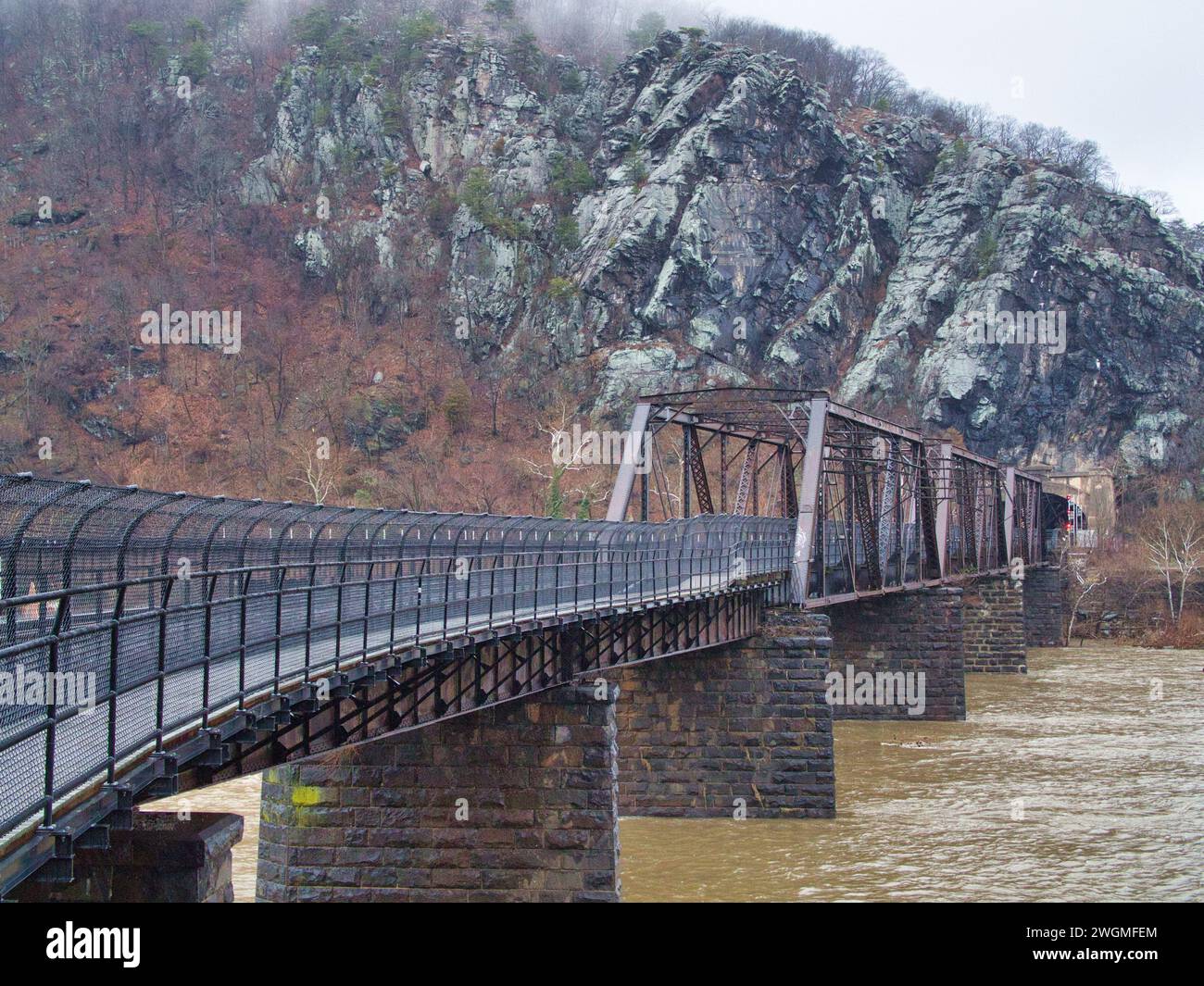 Railroad bridge and train tunnel over Potomac River and through Appalachian Mountains in Harpers Ferry, WV, in the winter. Stock Photo