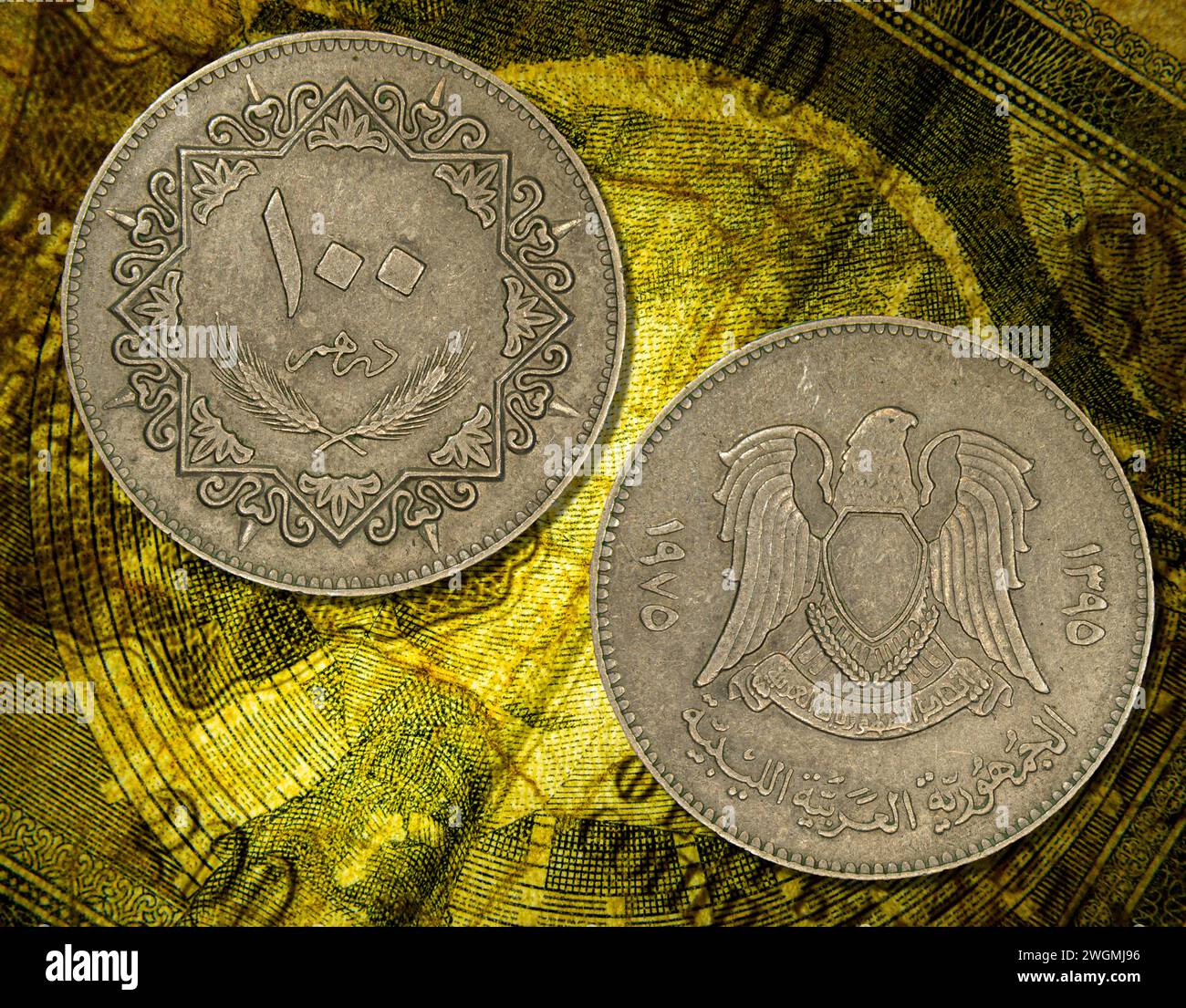 Two vintage Libyan Jamahiriya dinar coins placed on a vibrant yellow background Stock Photo