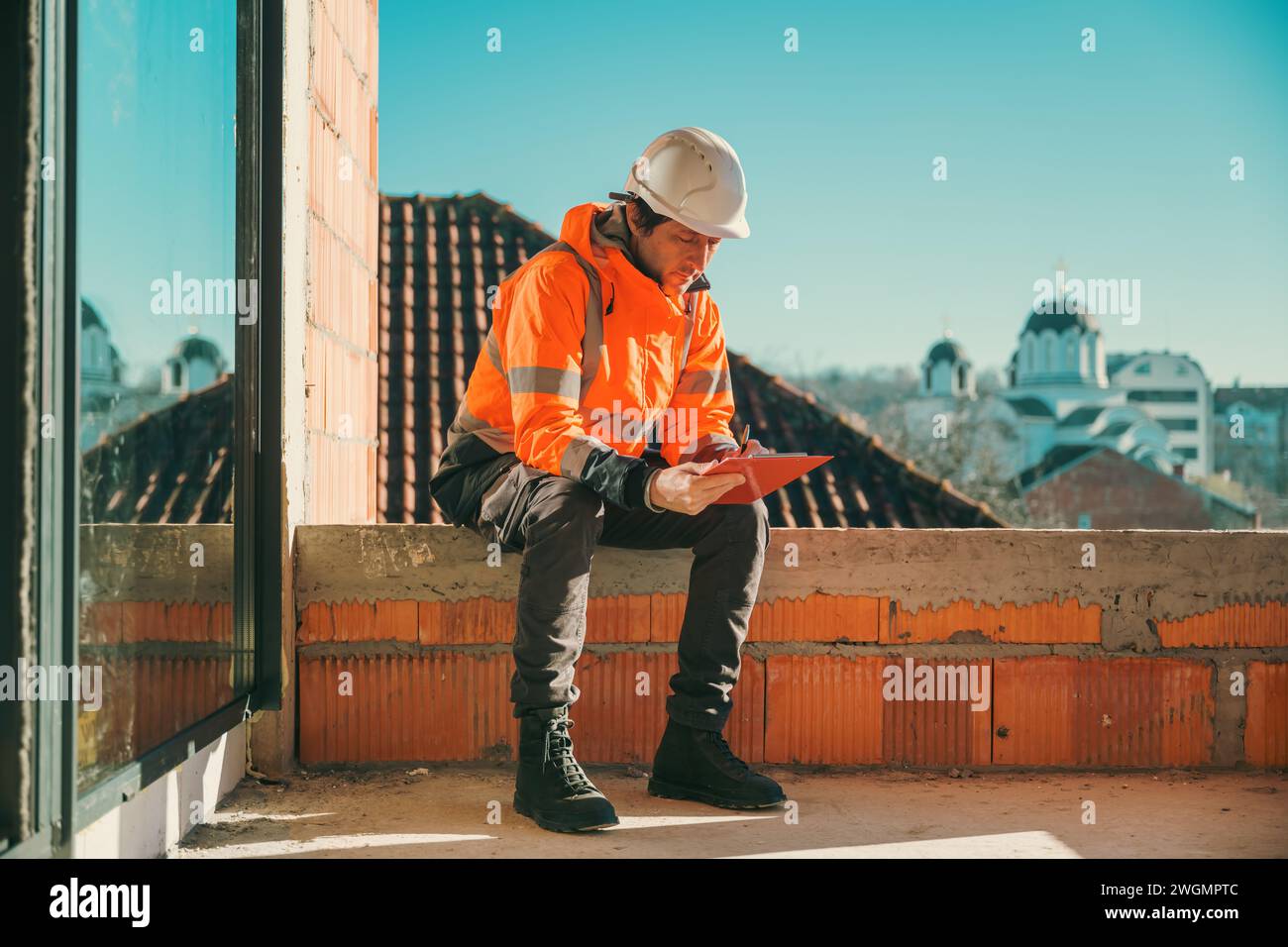 Architect and construction engineer making notes and remarks during building site inspection, selective focus Stock Photo