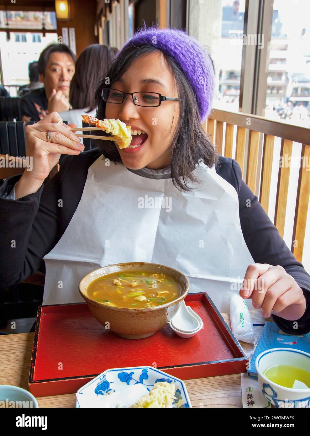 An Asian woman eating ebi tempura with Japanese curry in a restaurant in Gion, Kyoto, Japan
