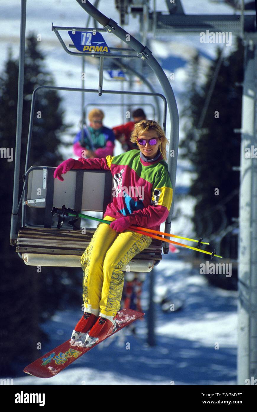 Sport SKI pretty blond hair young woman sit down ski lift snow winter forest background healthy good looking Stock Photo