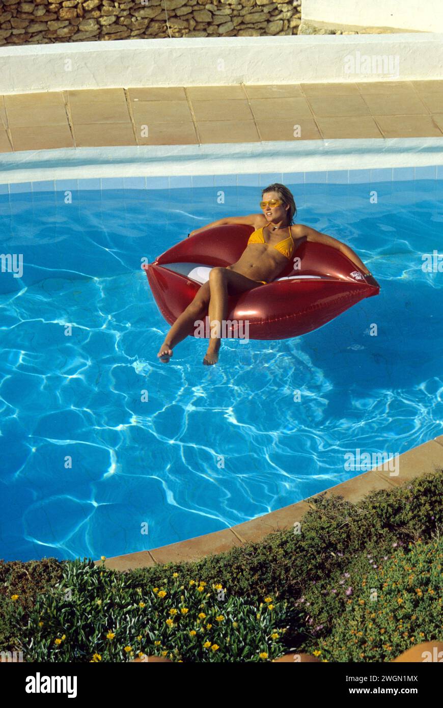 pretty blond hair young woman lay down on inflattable pneumatic in pool summer holidays Stock Photo