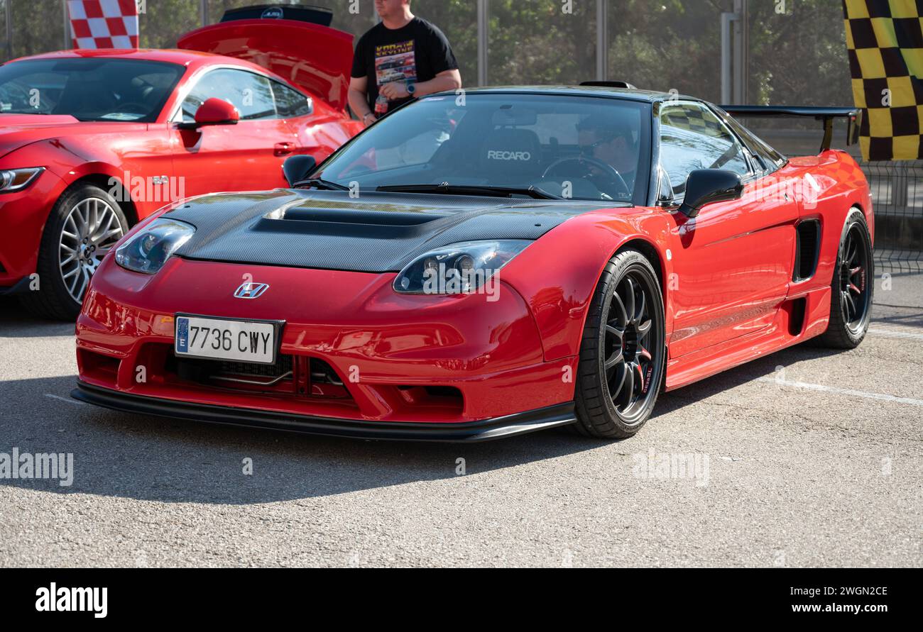 Front view of a stunning midengine V6 Honda NSX. It is red with black