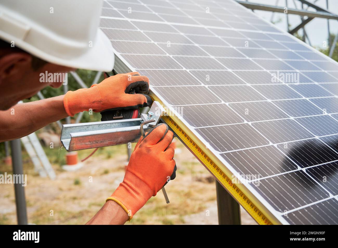 Worker measuring solar panel with measuring tape while installing this ...