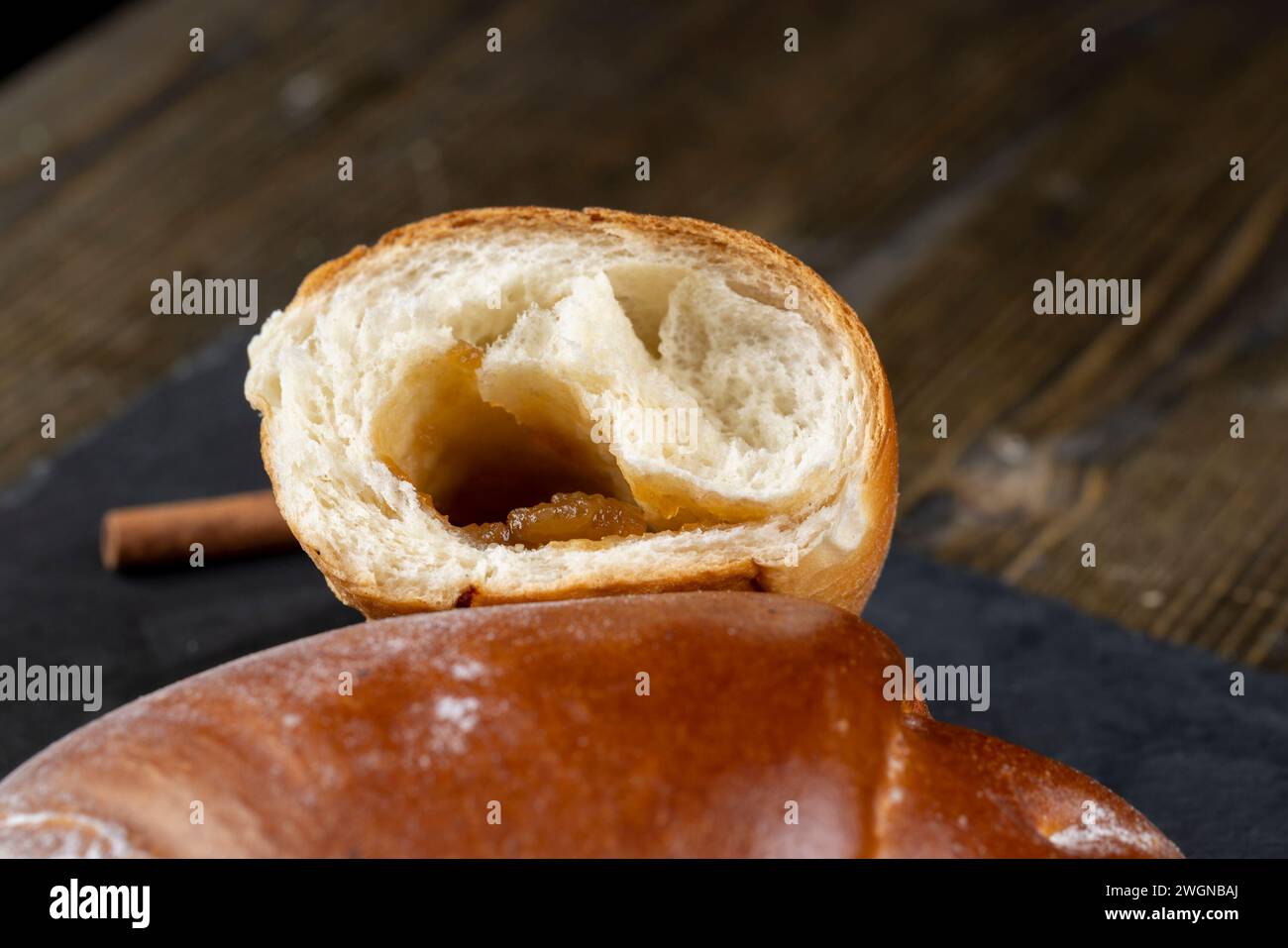 such a bun in jam on the table, a half-broken bun for tea Stock Photo