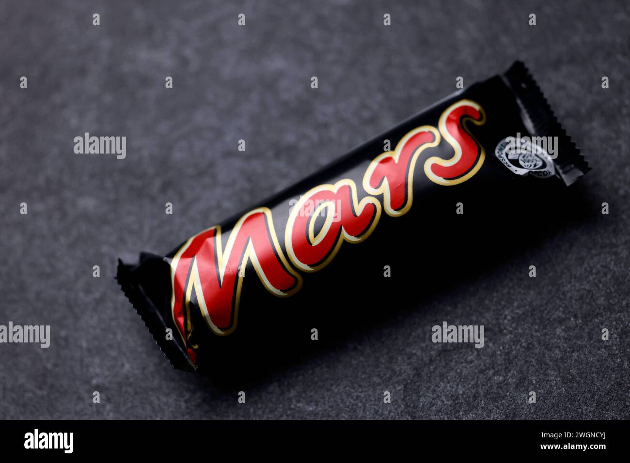Ein Mars-Schokoriegel liegt auf einer Steinplatte. Mars ist ein von Mars Incorporated hergestellter mit Schokolade überzogener Karamellriegel. Er besteht aus Candycreme mit einer darüber liegenden Schicht Karamell, umgeben von Milchschokolade. Nach einem längeren Streit stehen wohl bald wieder Mars-Produkte in den Regalen der Supermarktkette Edeka. Themenbild, Symbolbild Köln, 06.02.2024 NRW Deutschland *** A Mars chocolate bar lies on a stone slab Mars is a chocolate-coated caramel bar produced by Mars Incorporated It consists of candy cream with a layer of caramel on top, surrounded by milk Stock Photo