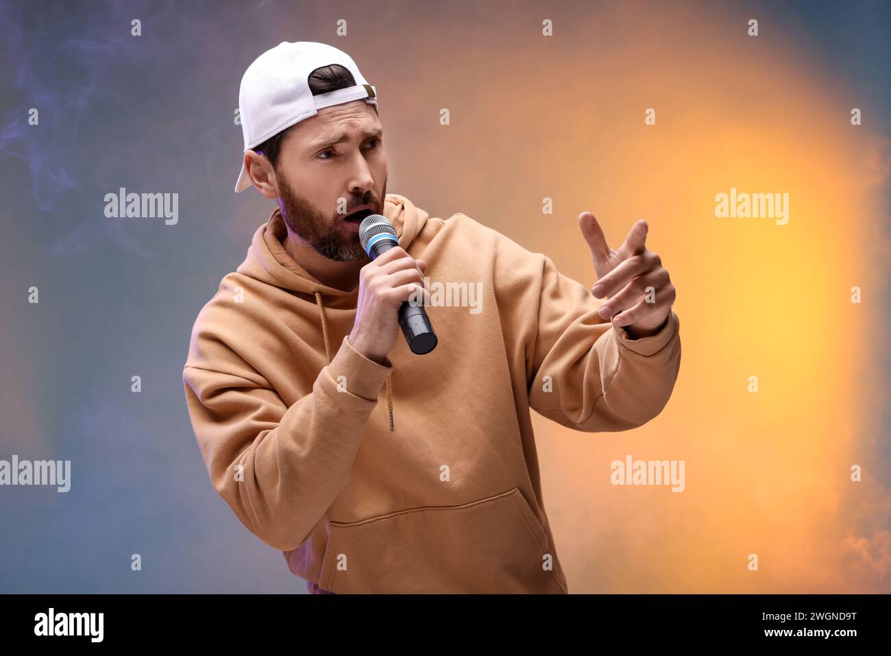 Singer with microphone rapping in color lights Stock Photo - Alamy