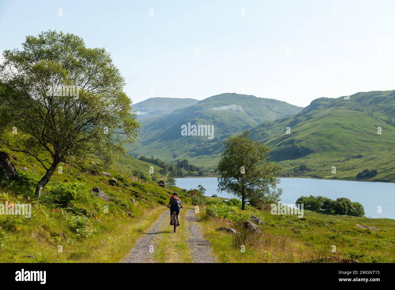 A cyclist on a rough track along Loch na Leitreach a very remote area of Scotland near Dornie. Stock Photo