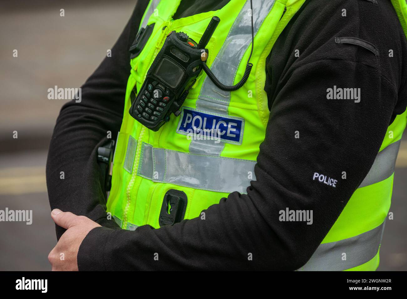 A close up of a policeman's wearing a high viz vest and radio Stock Photo