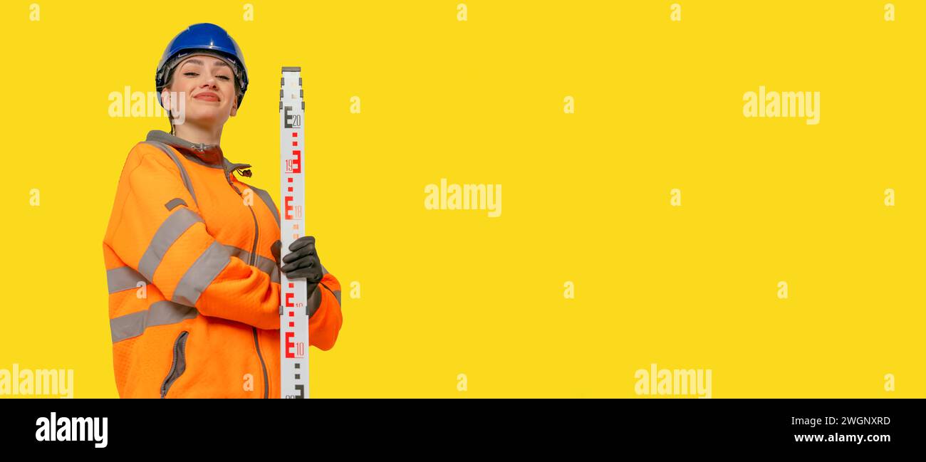 Woman in hard hat and protective clothes land surveyor working with ...