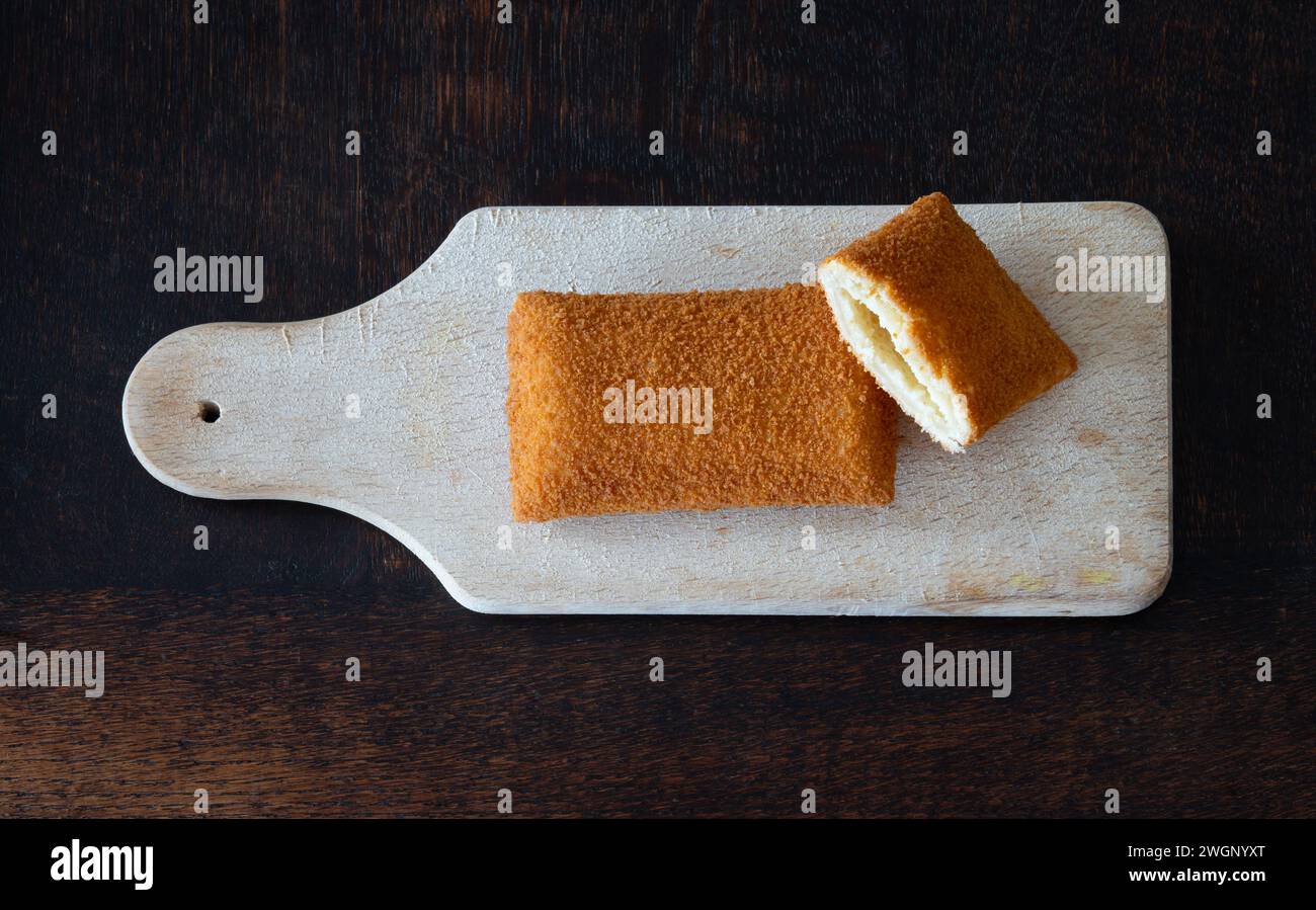 Kaassoufflé on wooden cutting board,  a popular dutch fast food snack isolated, top down view Stock Photo