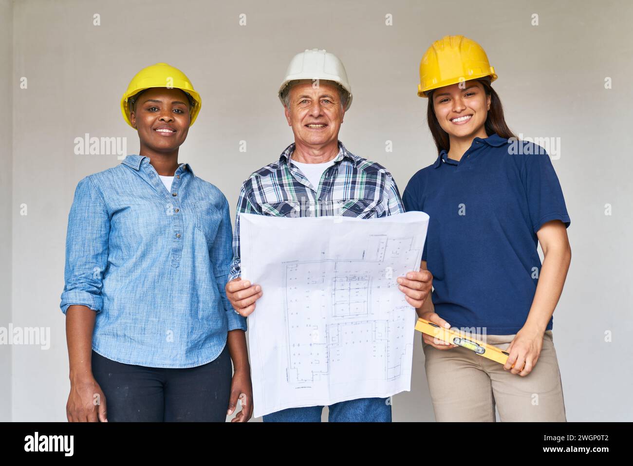Construction workers standing with blueprint design Stock Photo