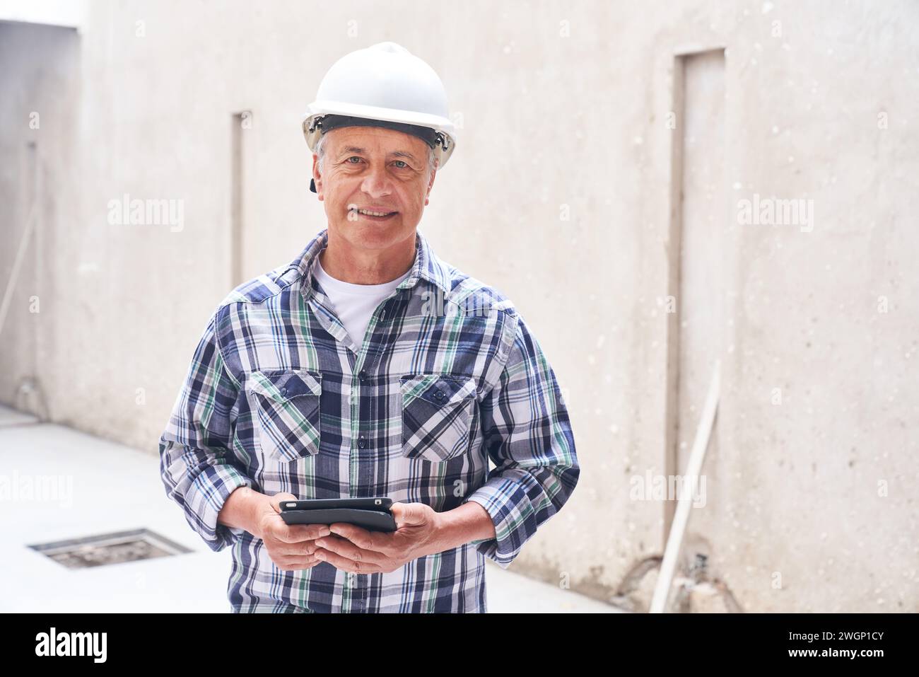 Smiling senior male contractor with tablet PC Stock Photo