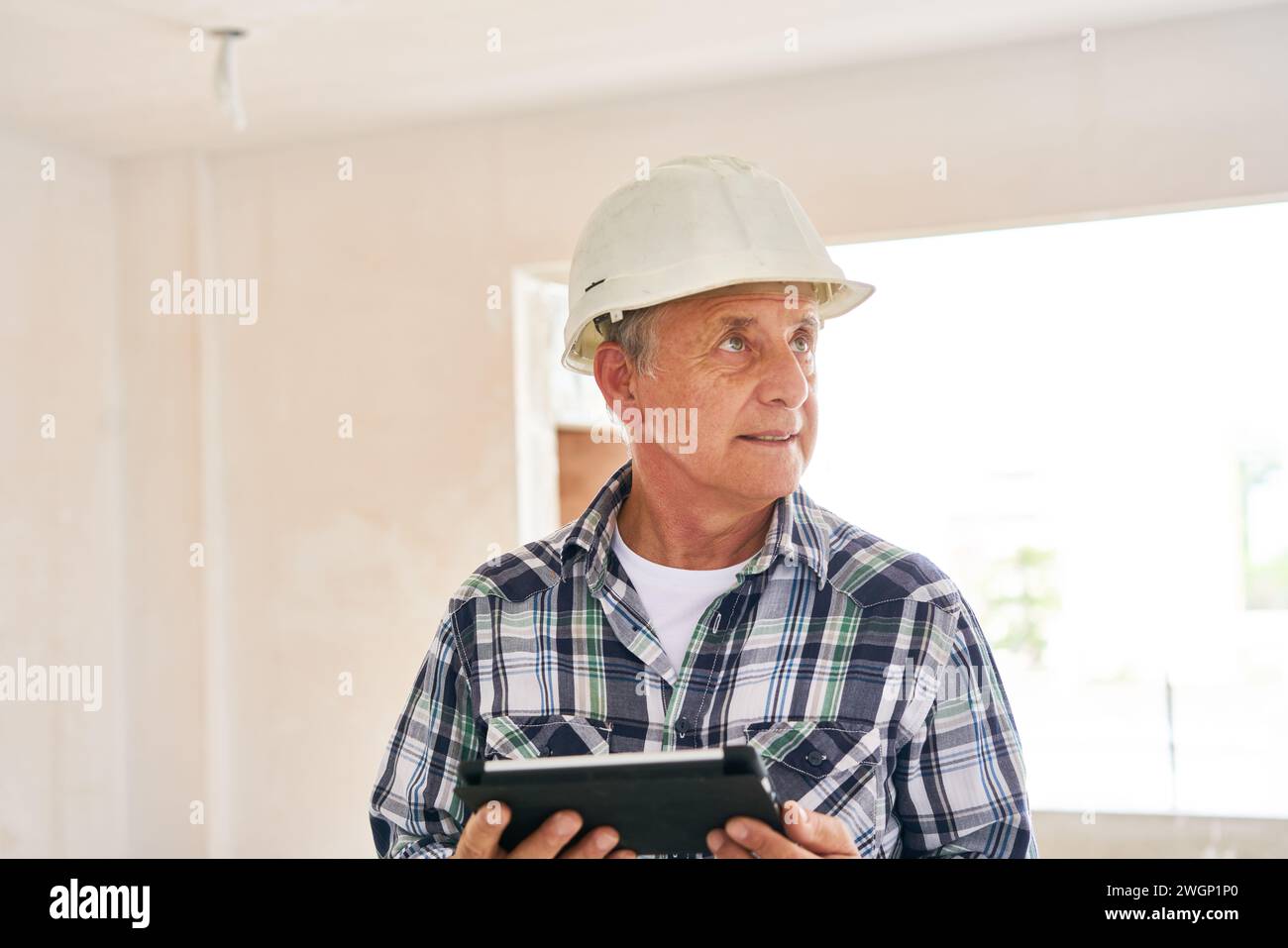 Architect wearing hardhat holding tablet PC Stock Photo