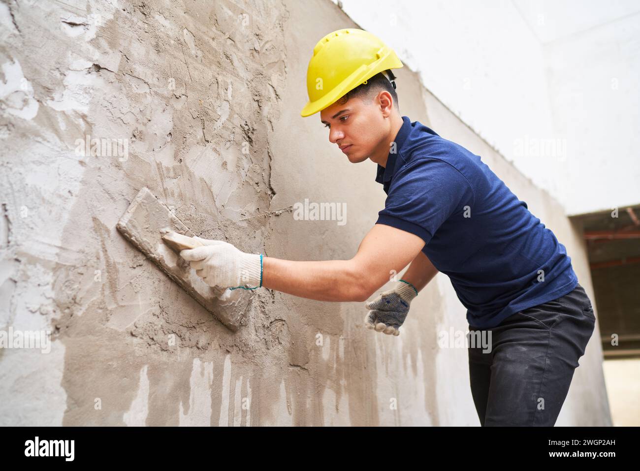 Male labor plastering on wall with cement Stock Photo
