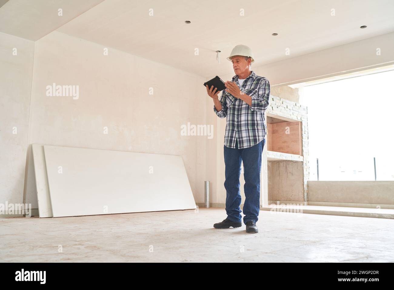 Architect wearing hardhat using tablet PC Stock Photo