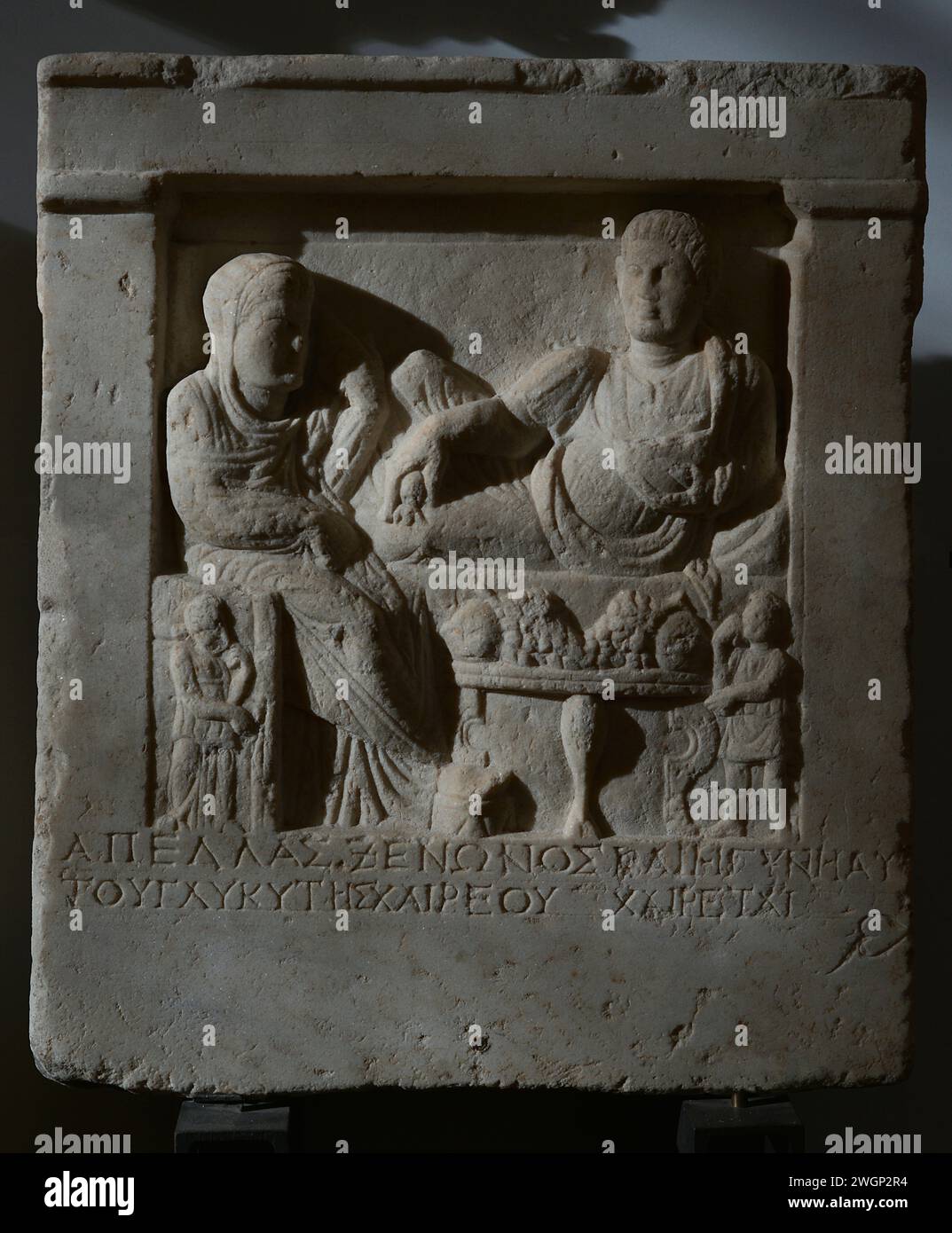 Funeral feast: a woman, a man and servants. Inscription in Greek. Stele of Apellas, son of Xenon, and his wife Glykytes, daughter of Haireos. Early Roman Empire. National Archaeological Museum. Sofia. Bulgaria. Stock Photo