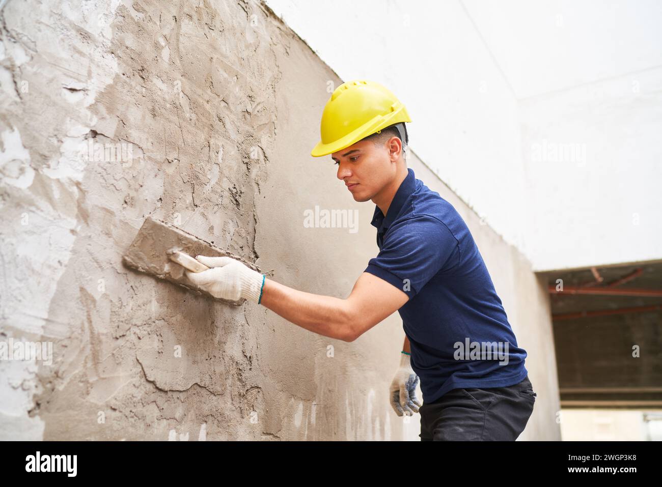 Male labor applying cement on wall Stock Photo