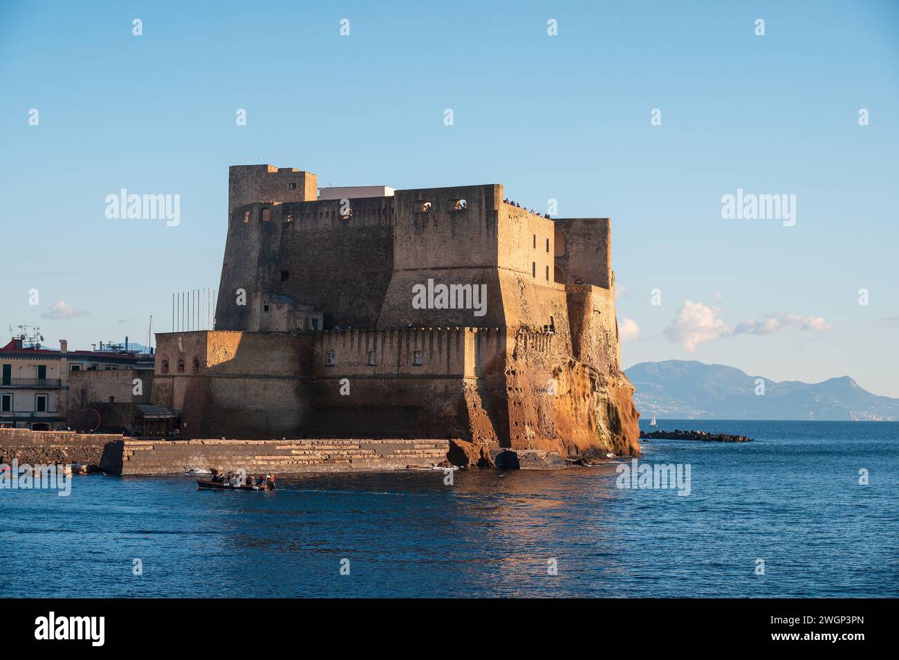 Naples, Italy - December, 18, 2022: Overlooking the serene gulf of naples, a majestic Ovo Castle stone stands proudly on a rocky island. Iconic Castel Stock Photo