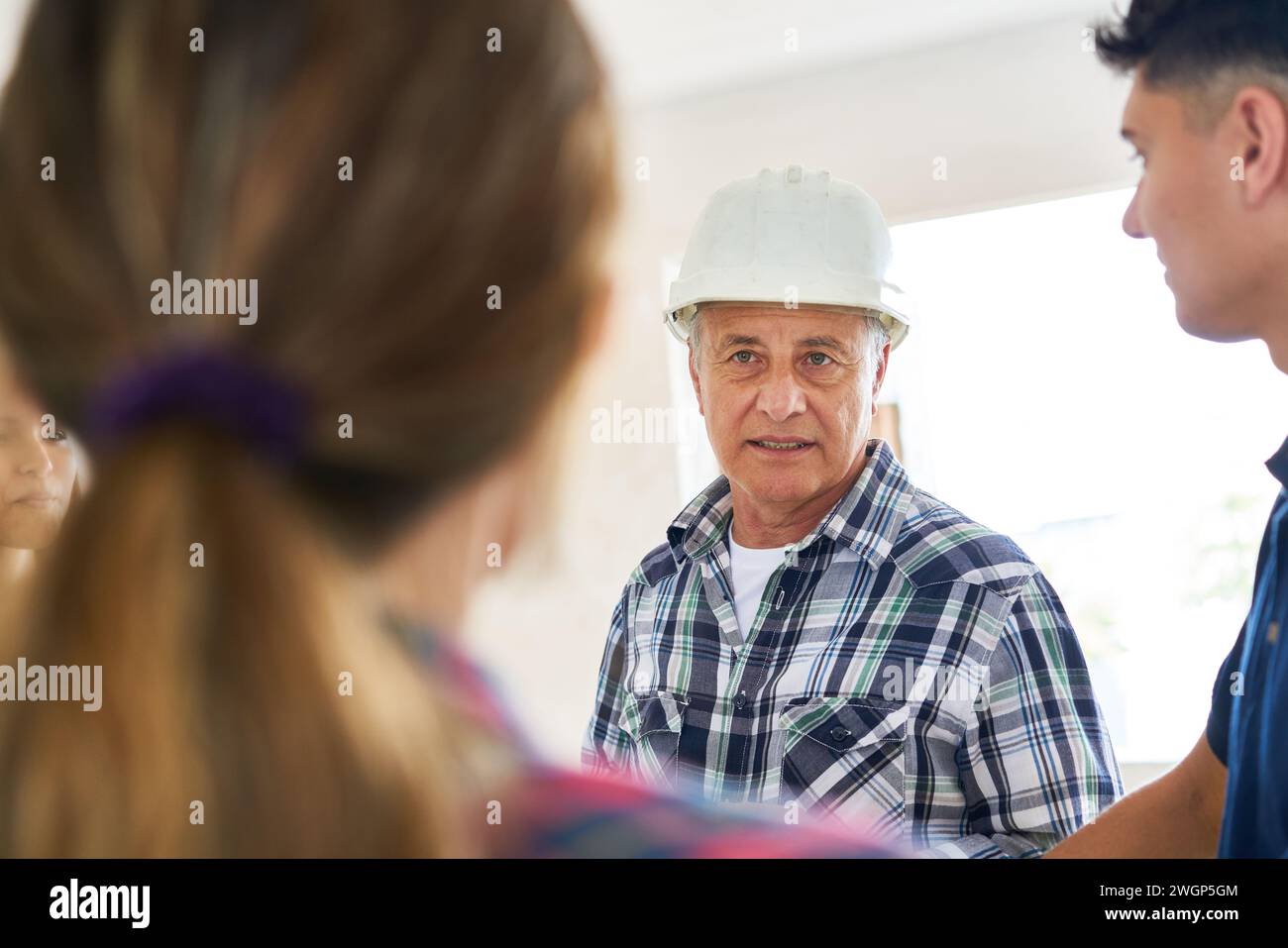 Confident male contractor looking at female worker Stock Photo