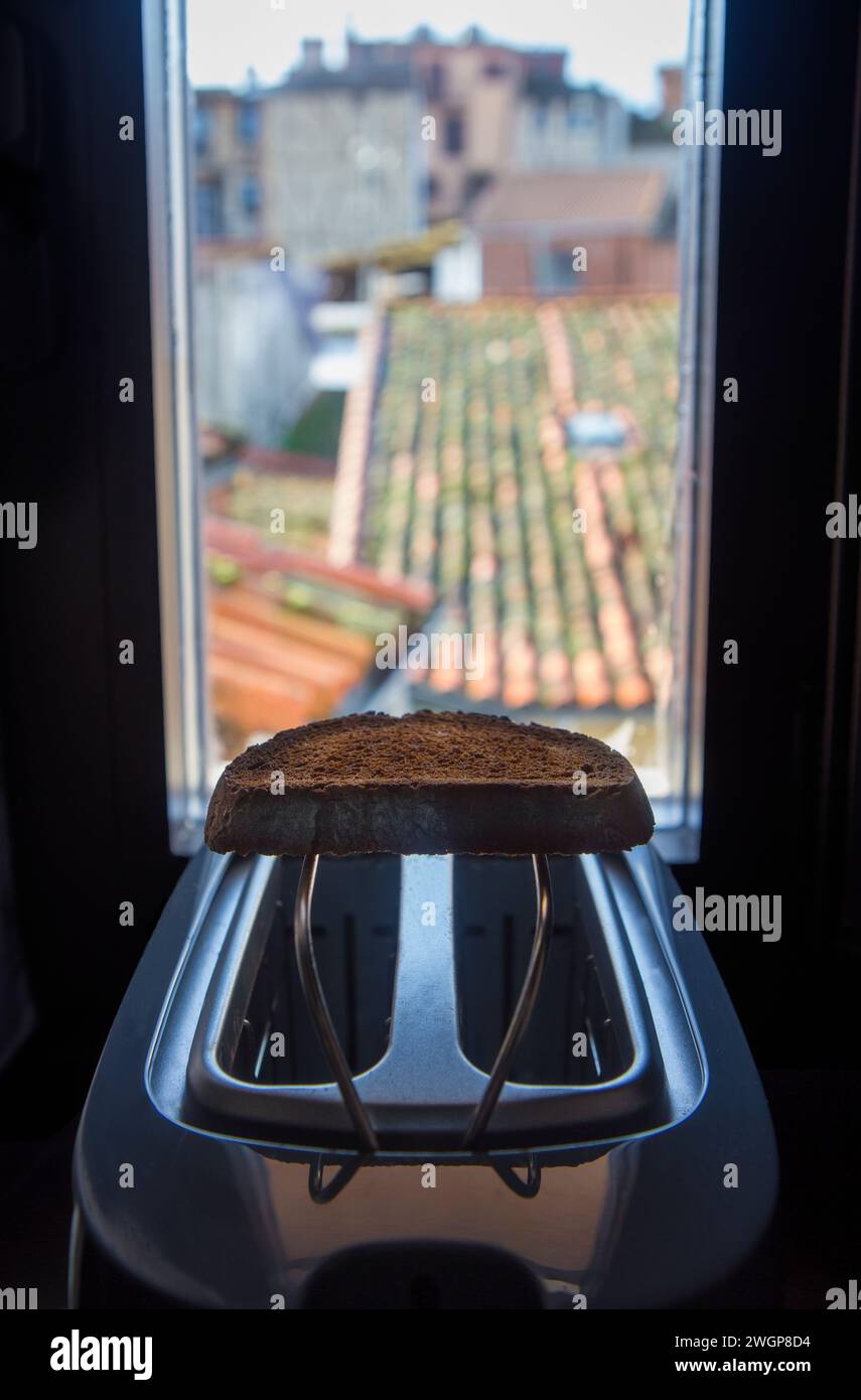 Toaster placed on the windowsill of a rural house. Fresh made slice over rack Stock Photo