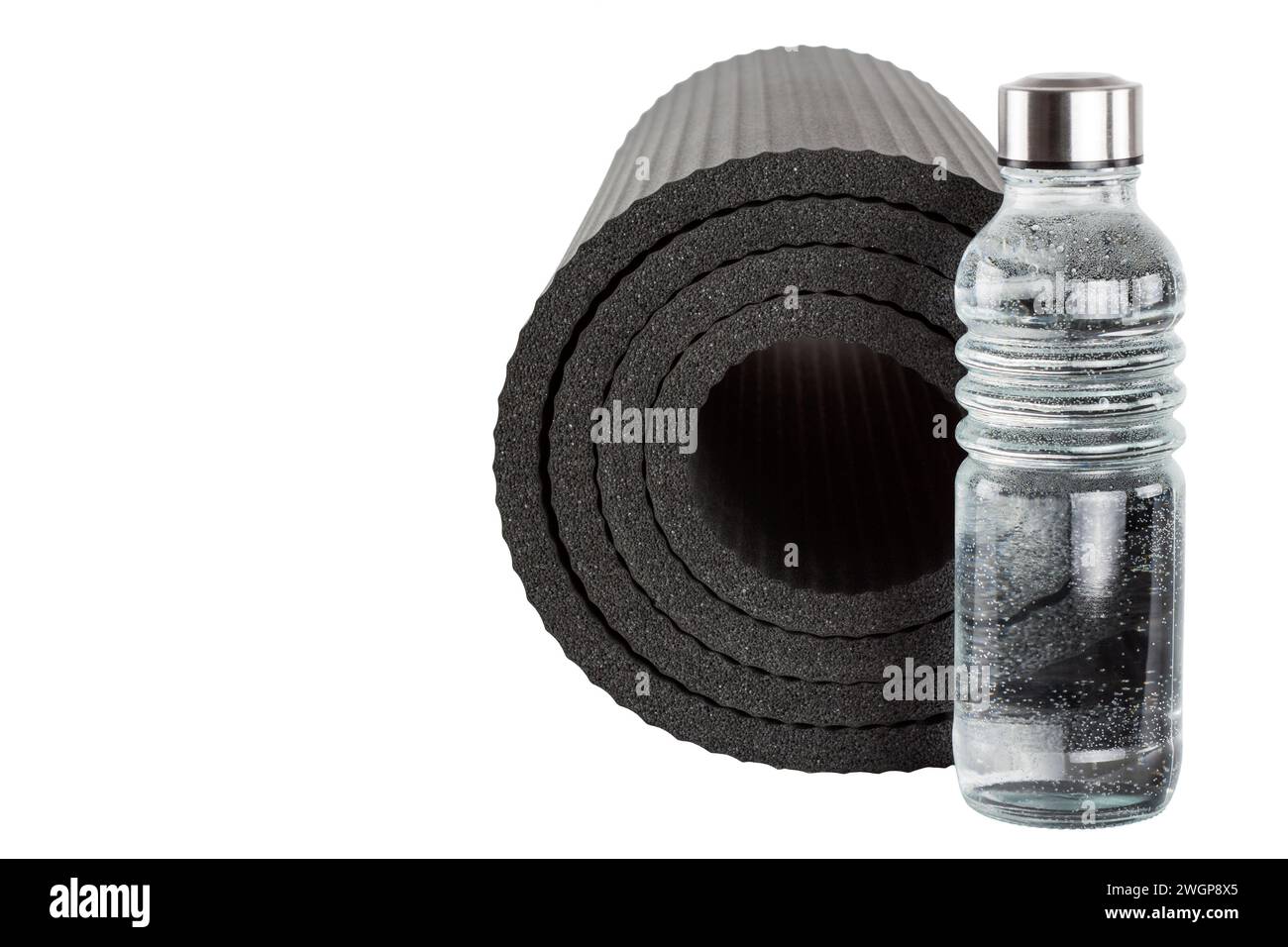 Yoga mat with a bottle of water isolated on a white background Stock Photo