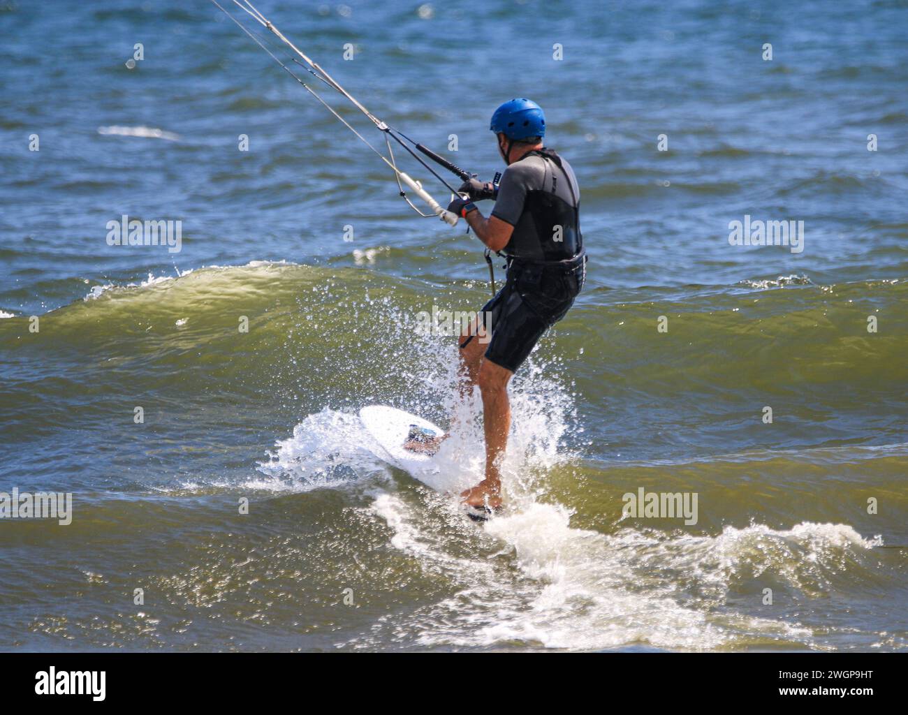 One man crashing into the waves while riding on a kiteboard in the Atlantic Ocean. Stock Photo