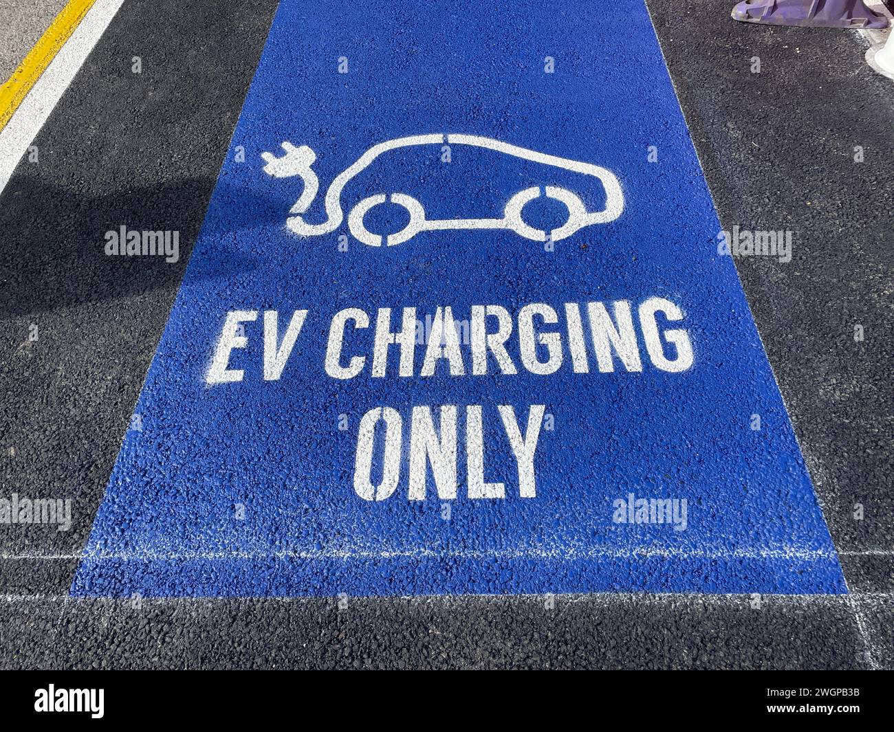 An electric vehicle charging point is indicated by tarmac painted blue