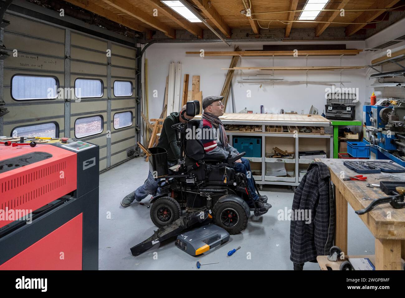 Mechanic working on mans prototype wheelchair Stock Photo