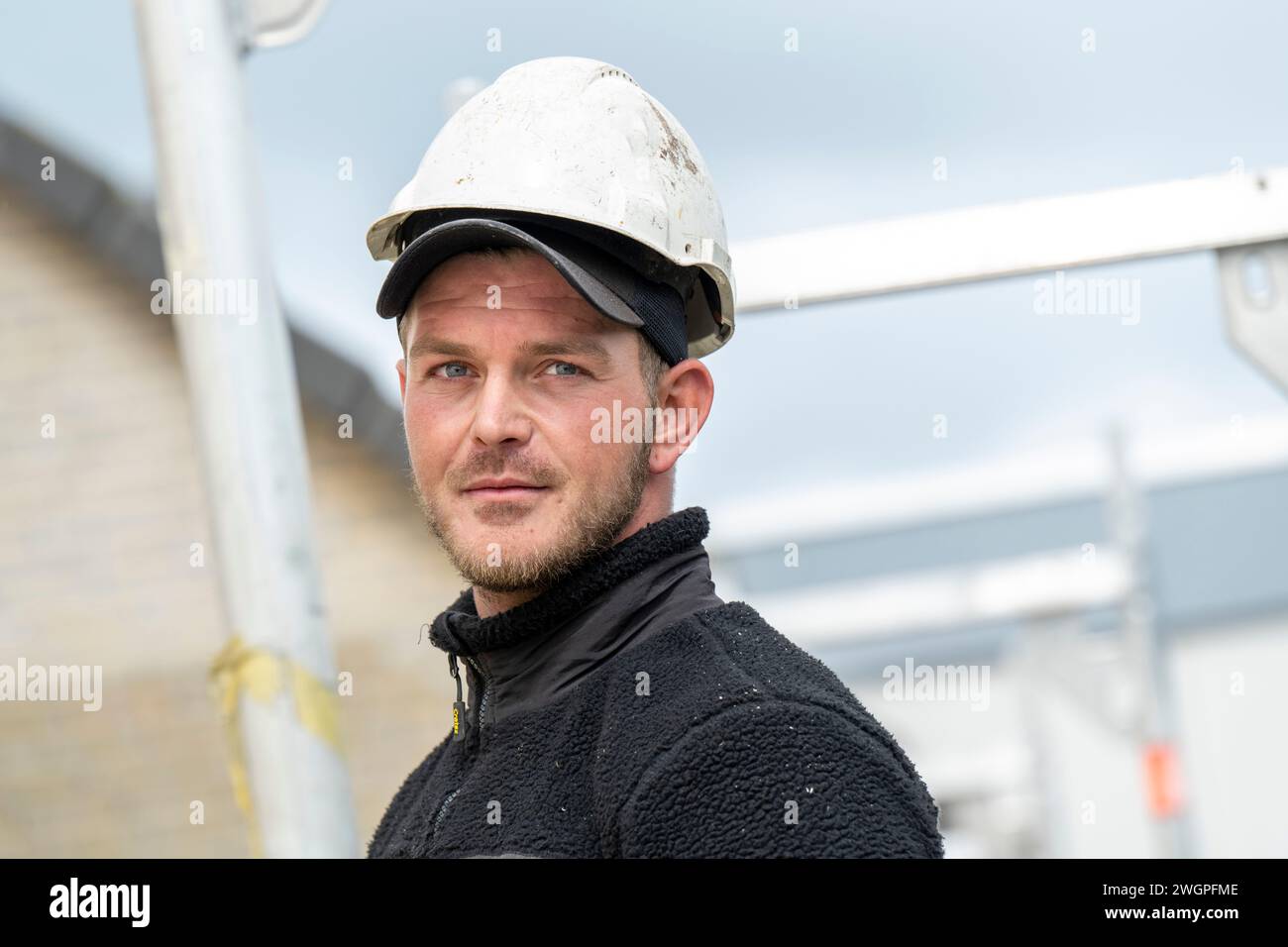 Portrait of tradesman on a roof wearing safety gear and hard hat Stock