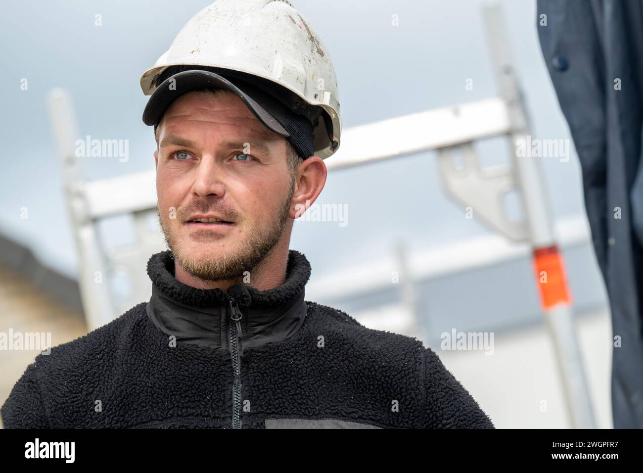 Portrait of tradesman on a roof wearing safety gear and hard hat Stock