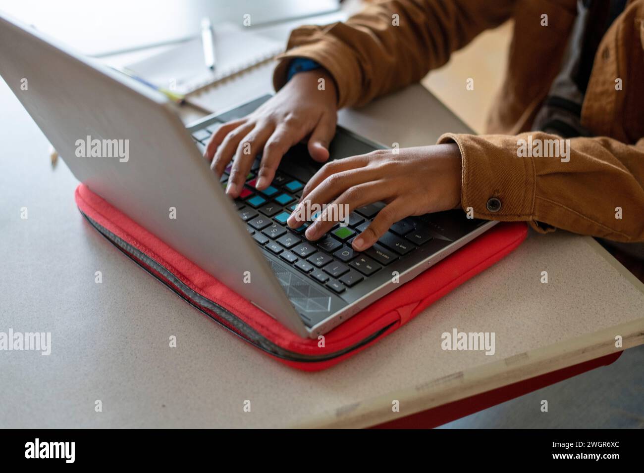 Close up of a mixed raced student working on his laptop in class Stock Photo