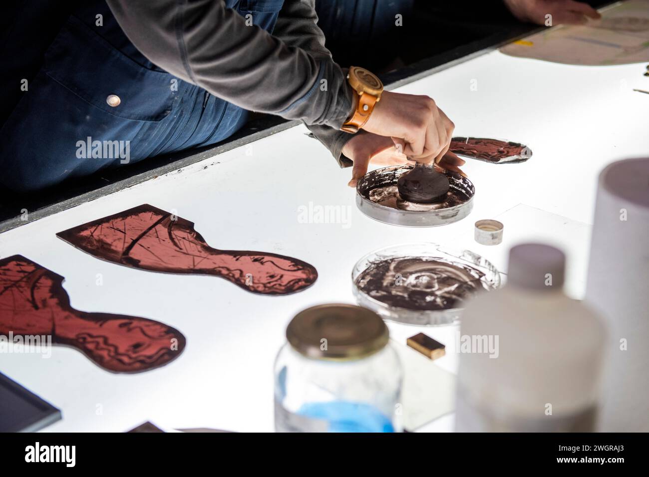 Apprentice female stained glass worker being taught lessons from