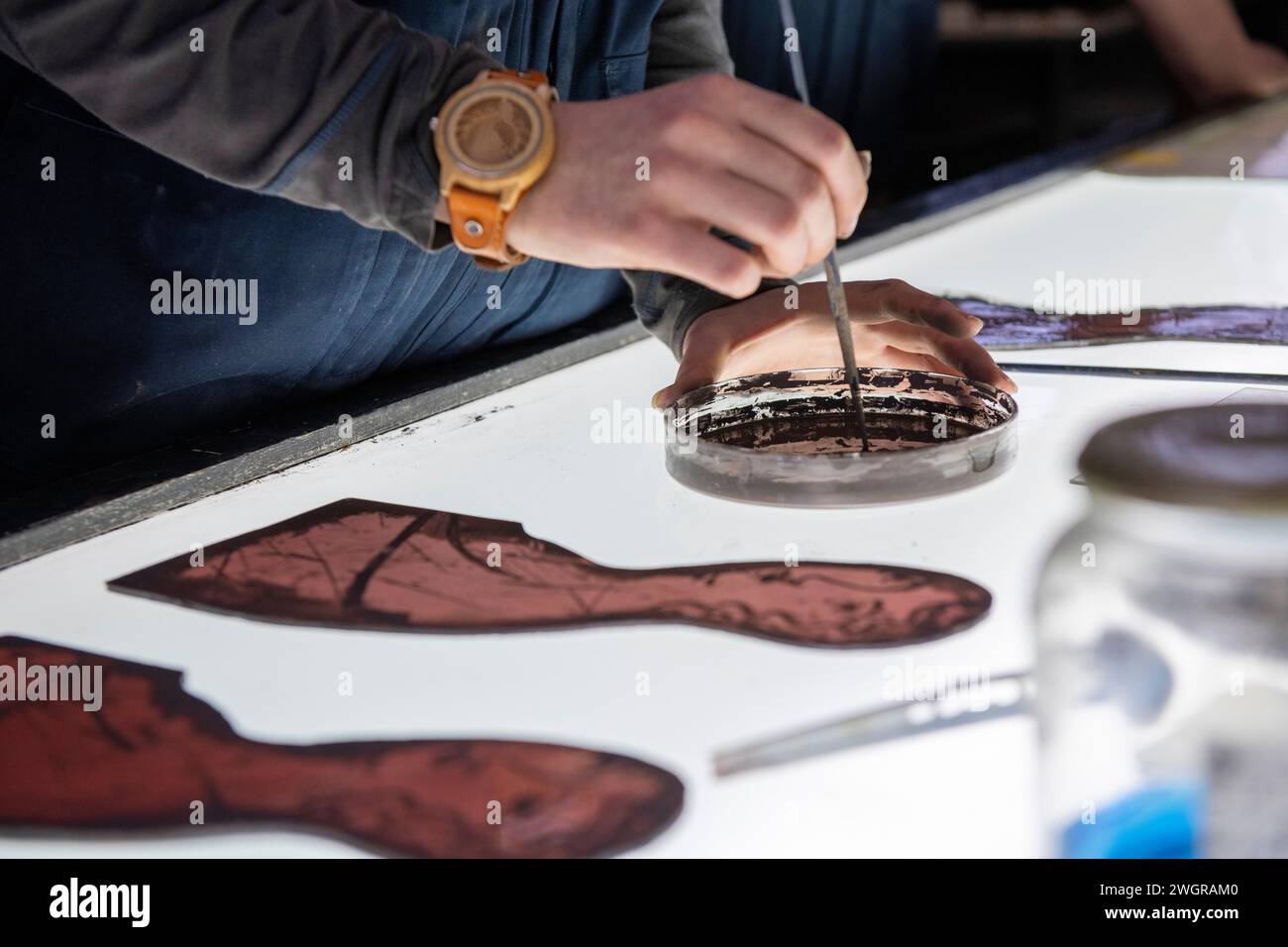 Apprentice female stained glass worker being taught lessons from