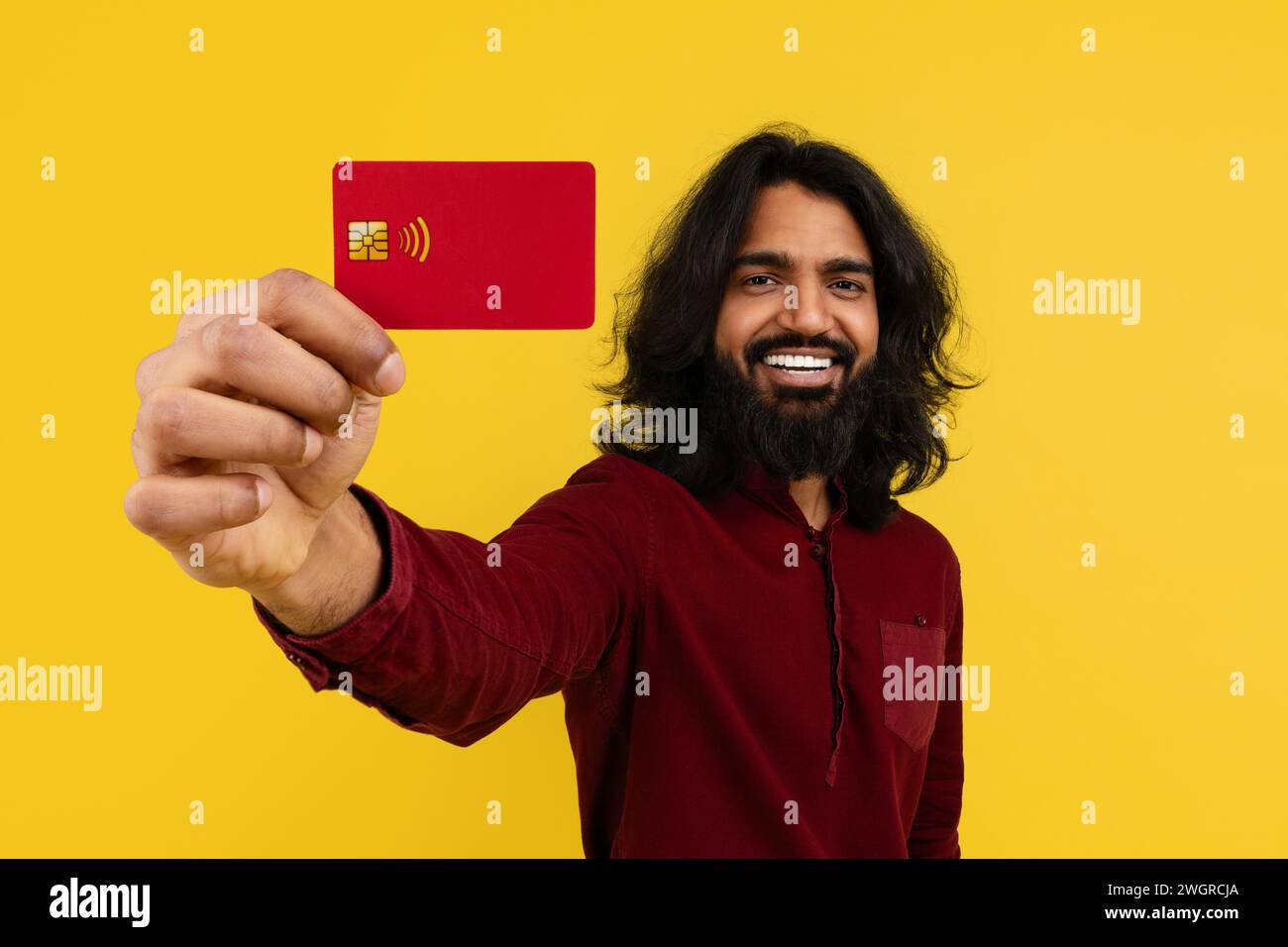 Cheerful young indian guy showing bank card Stock Photo - Alamy