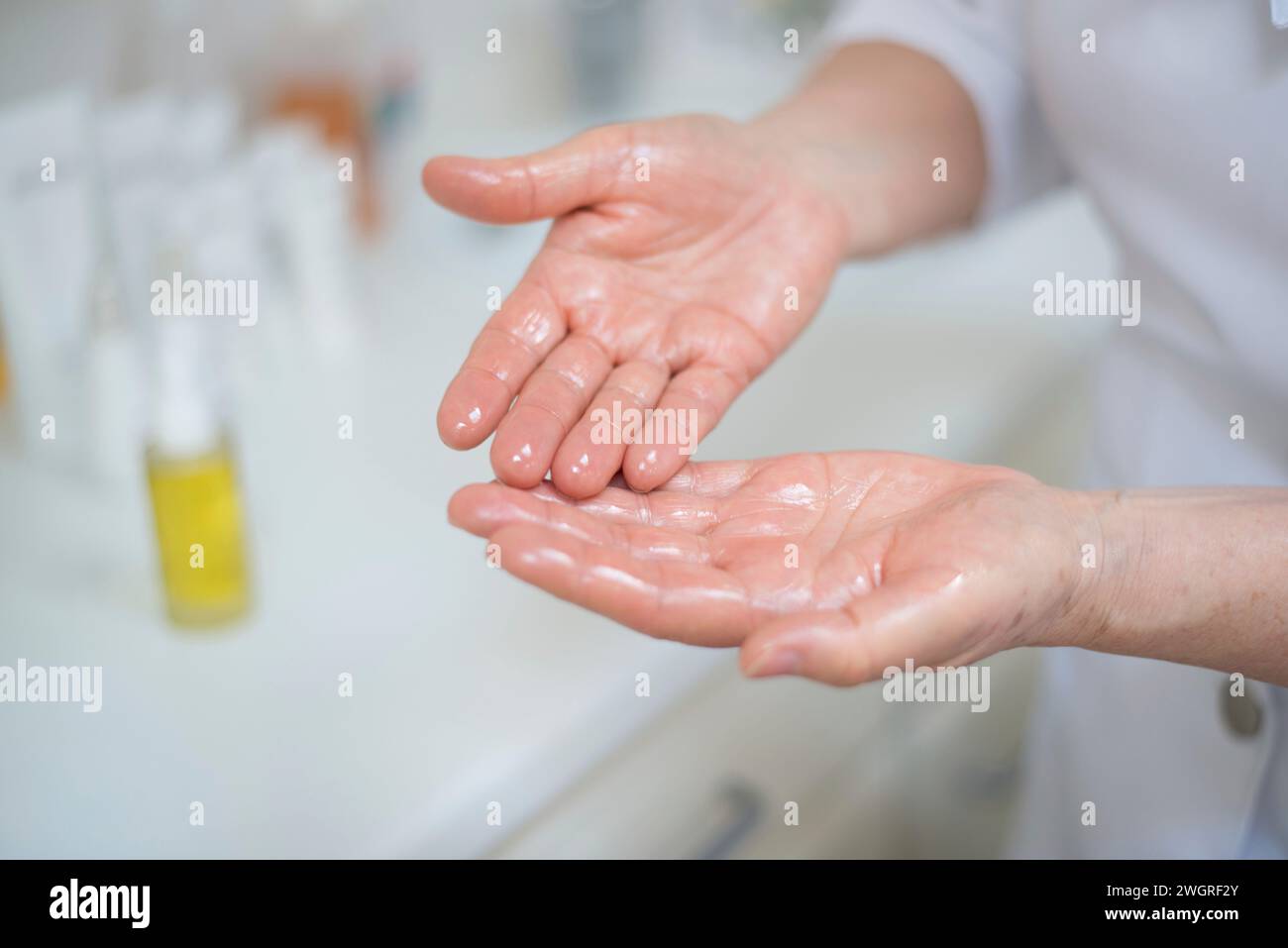 Female Beauticians hands applying oil Stock Photo - Alamy
