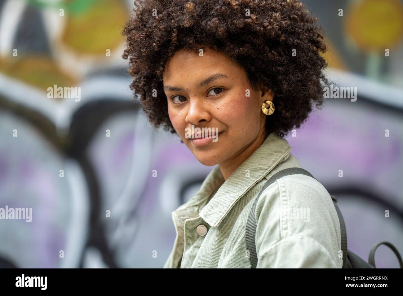 NTrendy young mixed race African woman walking through town happy. Stock Photo