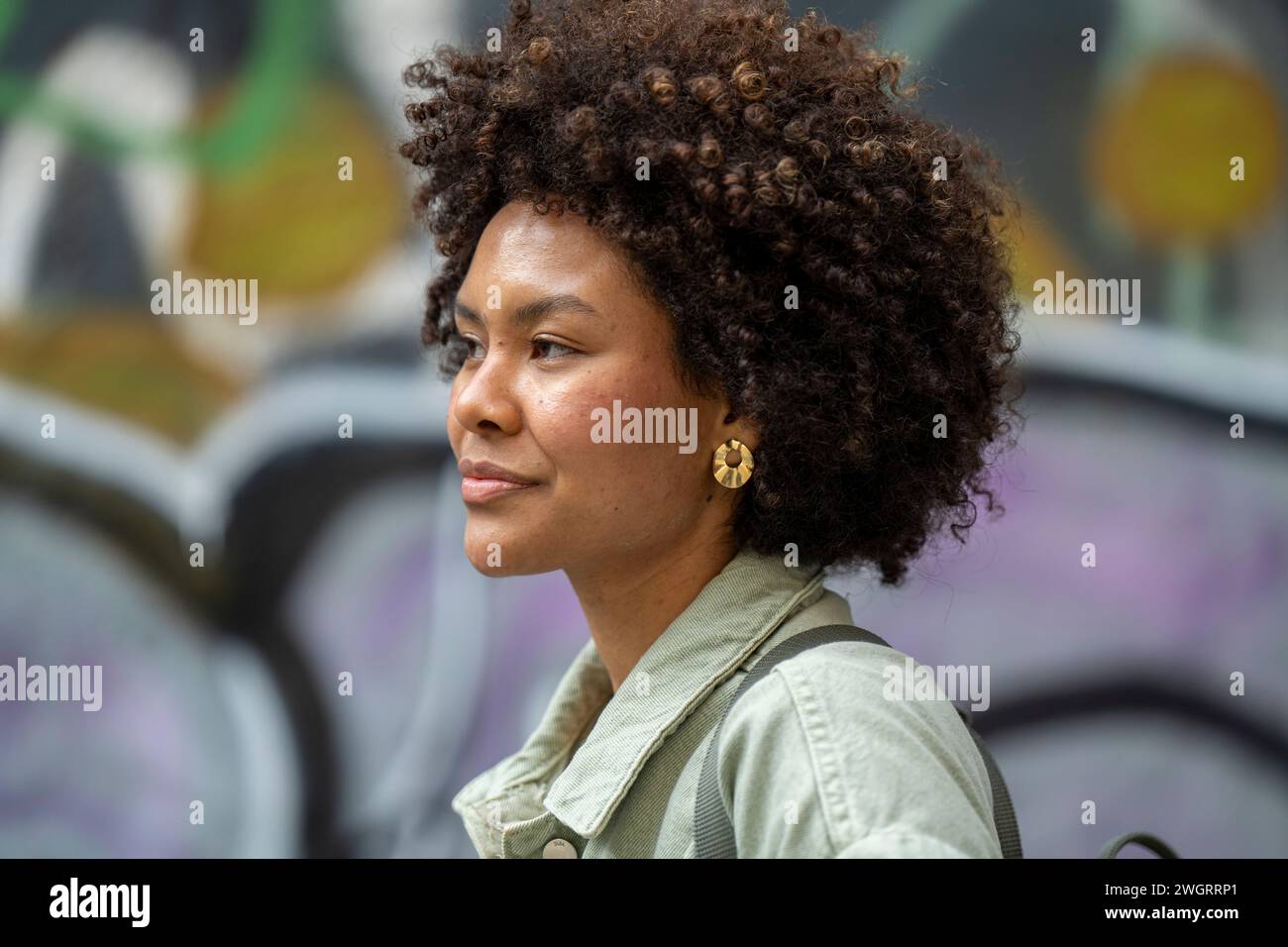 Trendy young mixed race African woman walking through town happy. Stock Photo