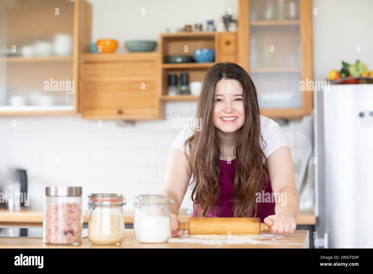 young woman making a pizza in a kitchen Stock Photo