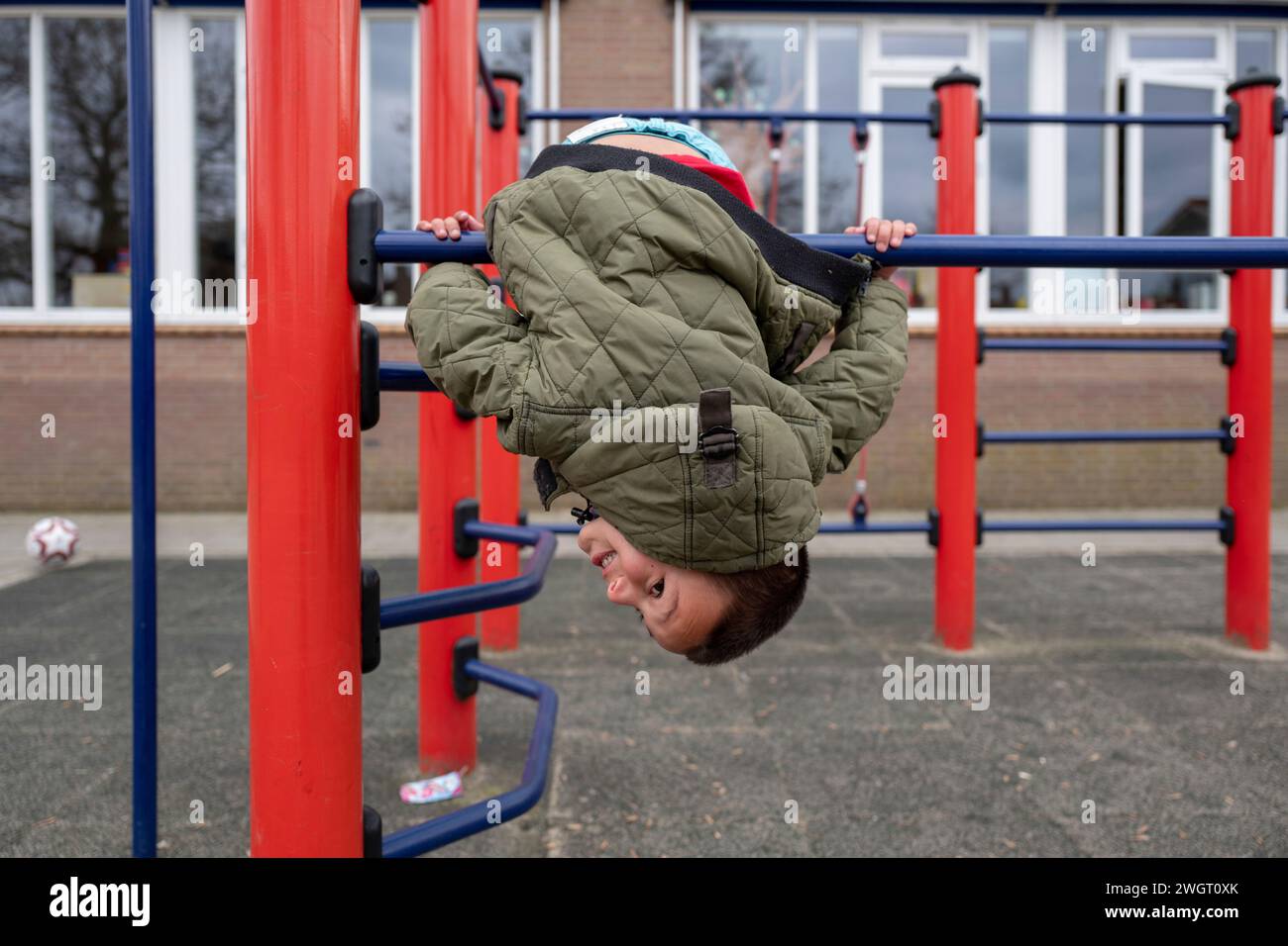 Boy jumping through bars at a park, swinging over the top Stock Photo