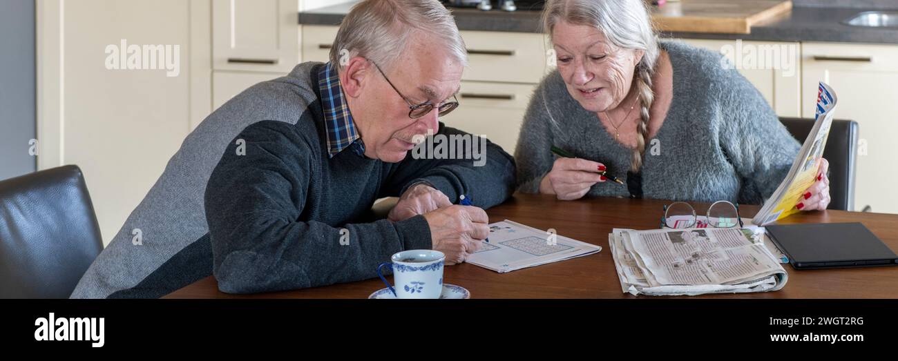 Elderly couple sitting at their dining room table discussing their finances for retirement Stock Photo